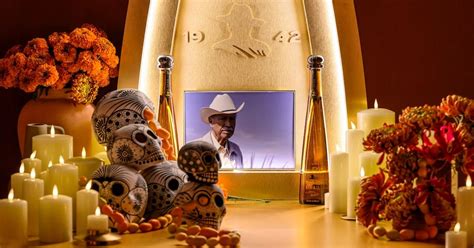 Ofrenda de Día de Muertos con velas, flores de cempasúchil y fotos de ancianos