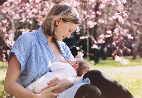 Madre amamantando a su bebé en un espacio público de forma natural y discreta, con enfoque en la interacción madre-hijo.