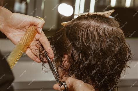 Voluntario peluquero cortando el pelo a una persona mayor en una residencia