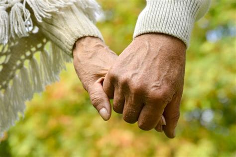 Pareja de adultos mayores tomados de la mano, simbolizando apoyo mutuo