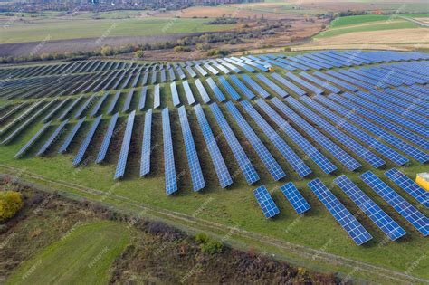 Imagen de una planta solar fotovoltaica comunitaria con paneles solares y un grupo de personas observándola
