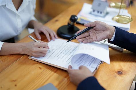 Abogado explicando un contrato o documento legal a un cliente en una oficina.