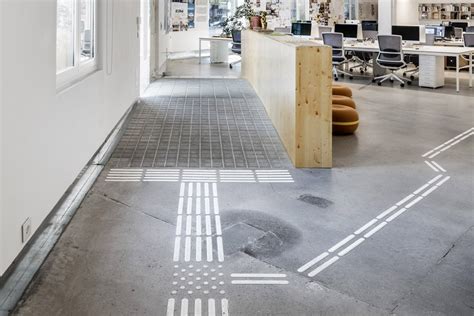 Interior de oficina accesible con itinerarios señalizados con bandas