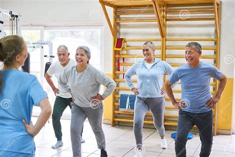 Foto de grupo de adultos mayores haciendo ejercicios de estiramiento en una clase grupal