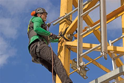 Foto temática: Trabajador con arnés y sistema de anclaje realizando labores en altura
