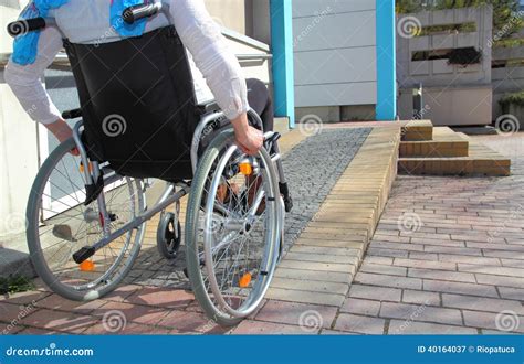 Persona en silla de ruedas utilizando una rampa de accesibilidad