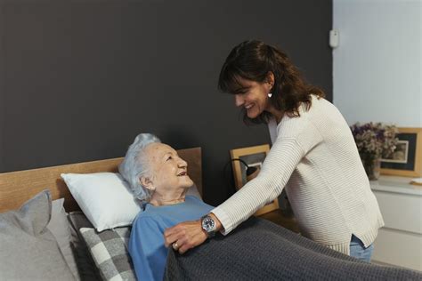Temática foto de una cuidadora amable asistiendo a un anciano en su casa