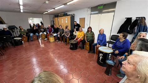 Adultos mayores tocando instrumentos de percusión en grupo