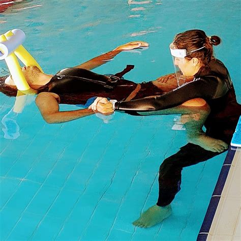 Niño con discapacidad disfrutando de la natación con un instructor en una piscina adaptada