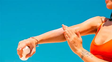 Diseñador: Ilustración de una persona aplicándose crema en un tatuaje de espalda con cuidado, destacando la importancia de una capa fina.