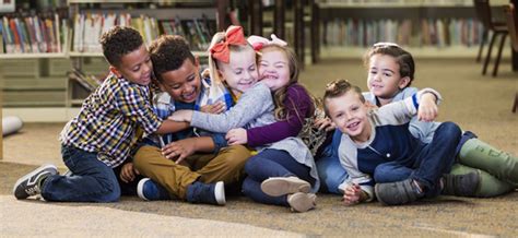 Foto de niños con y sin discapacidad auditiva jugando juntos en una clase de educación física