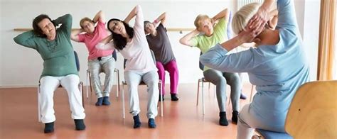 Foto de grupo de adultos mayores practicando yoga en silla