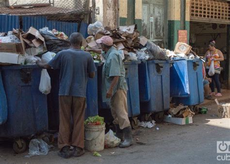 Fotografía de personas buscando en la basura en La Habana.