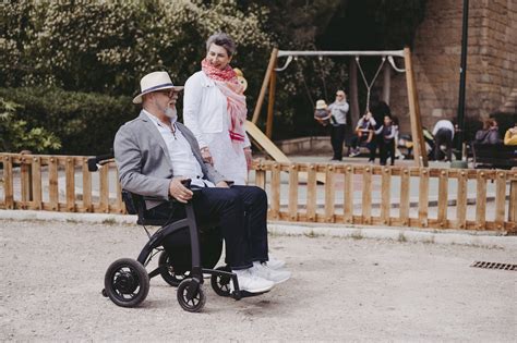 Foto temática de un adulto mayor utilizando una silla de ruedas con asistencia