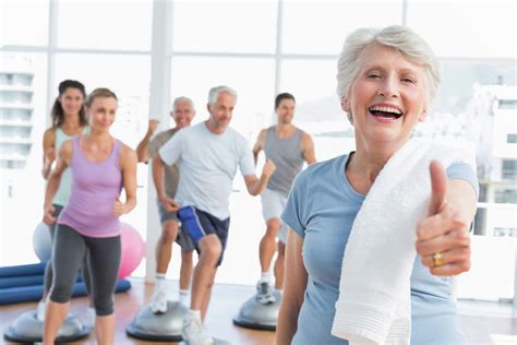 Persona mayor sonriendo mientras hace ejercicio ligero o yoga