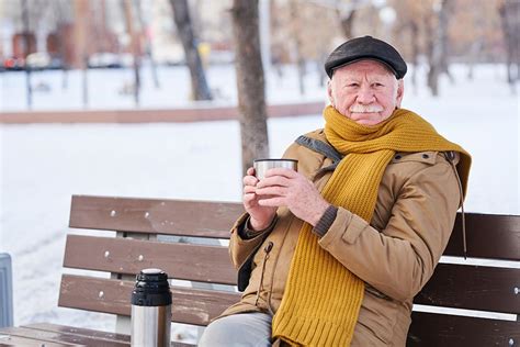 Fotografía de un anciano bien abrigado en invierno, con varias capas de ropa