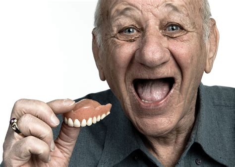 Foto de una persona mayor sonriendo con prótesis dentales