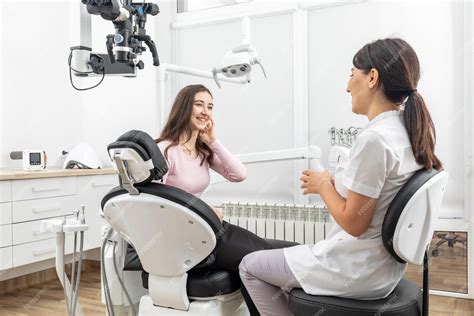 Foto de un dentista conversando empáticamente con un paciente anciano en una consulta