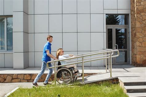 Persona con discapacidad utilizando una rampa accesible o mostrando una tarjeta de identificación
