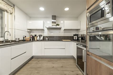 Cocina moderna con encimeras y electrodomésticos adaptados, incluyendo un horno bajo el nivel de la encimera.