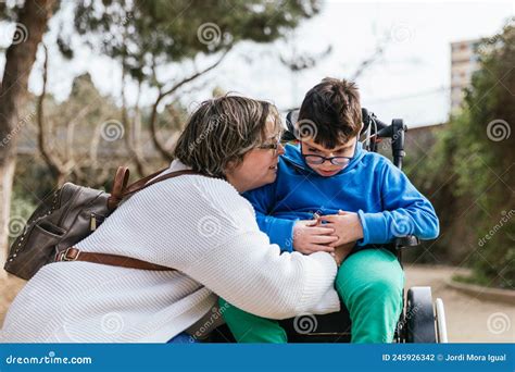 Foto de una madre abrazando a su hijo con discapacidad en un ambiente acogedor
