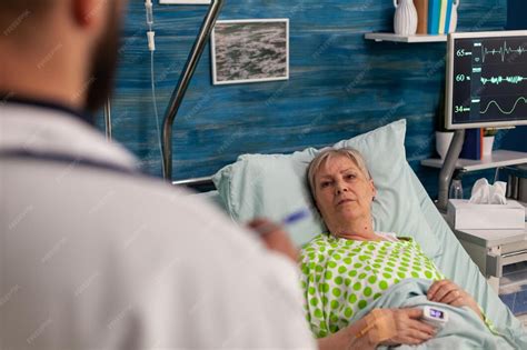 Persona mayor siendo examinada por un médico, con énfasis en la comunicación y observación de síntomas