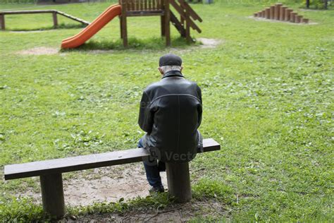 Foto de un anciano trabajando o barriendo en un parque