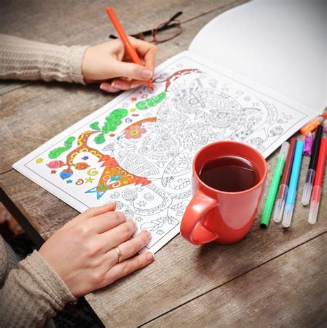Foto de un adulto coloreando un libro con patrones intrincados