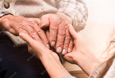 Manos de un anciano sosteniendo las manos de un niño