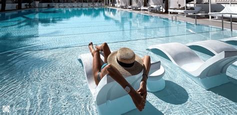 Anciano observando a una joven junto a una piscina en un hotel lujoso
