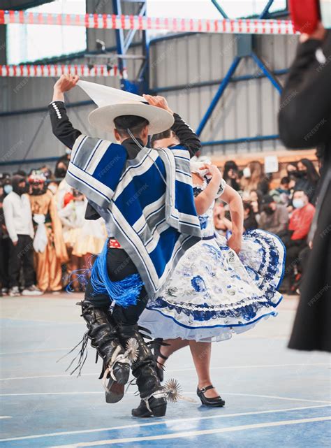 Foto de parejas de adultos mayores bailando cueca con entusiasmo en un escenario festivo