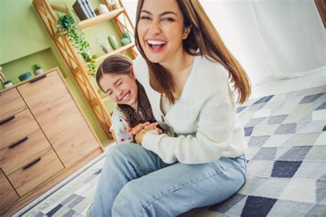 Hija y madre mayor riendo juntas mientras toman un café, simbolizando la conexión emocional