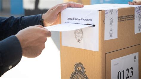 Foto de una urna electoral con personas votando, algunas de ellas de la tercera edad, recibiendo asistencia