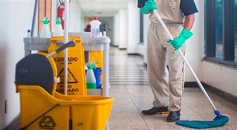 Fotografía de un auxiliar de servicios realizando tareas de limpieza y mantenimiento en un entorno institucional o educativo