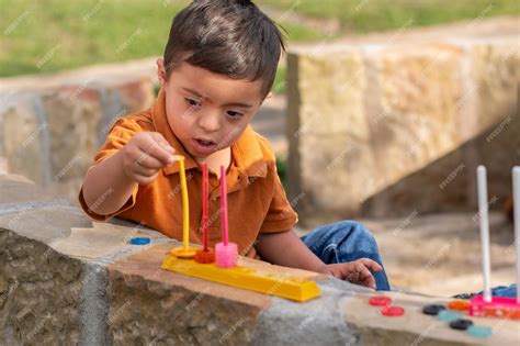 Fotografía de un niño con discapacidad intelectual sonriendo mientras juega con un andador adaptado al aire libre
