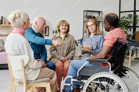 Varias personas mayores sentadas solas en un hogar de ancianos