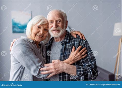 Pareja mayor abrazándose y sonriendo