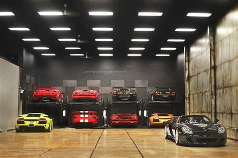 Fotografía de un garaje lleno de coches de lujo, incluyendo un Aston Martin DB9