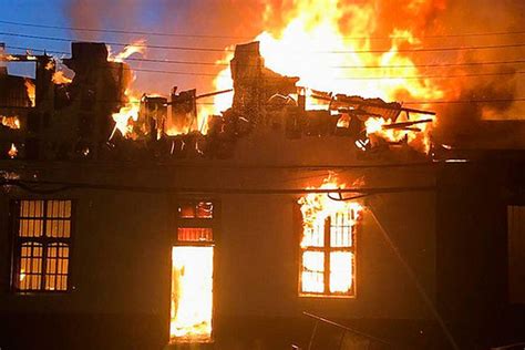 Vista general del hogar de ancianos tras el incendio, mostrando daños estructurales y la presencia de bomberos.