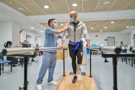 Fisioterapeuta trabajando con un paciente con discapacidad física en una sesión de rehabilitación