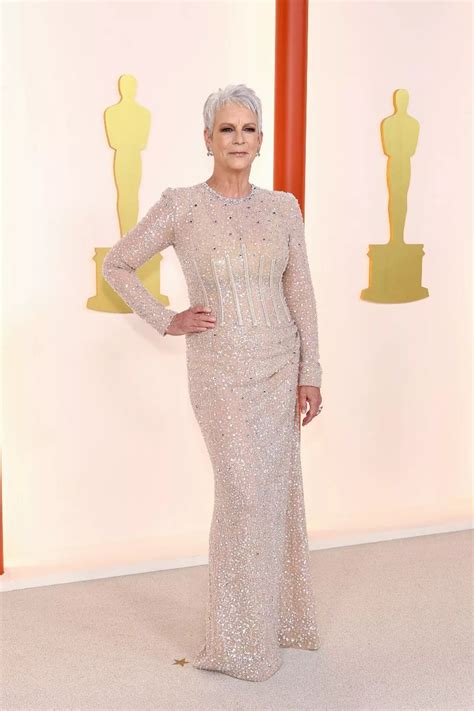Foto de Jamie Lee Curtis en la alfombra roja con un vestido escotado, mostrando confianza.