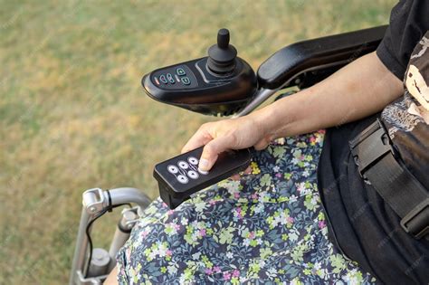 Silla de ruedas eléctrica moderna con joystick, persona mayor usándola de forma independiente