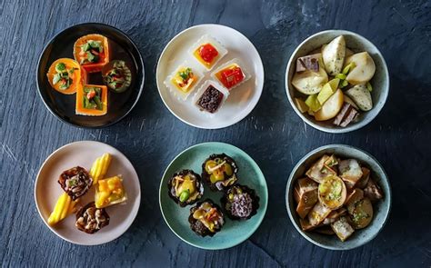 Mesa con pequeñas porciones de comida suave y nutritiva, rodeada de familiares en un ambiente acogedor