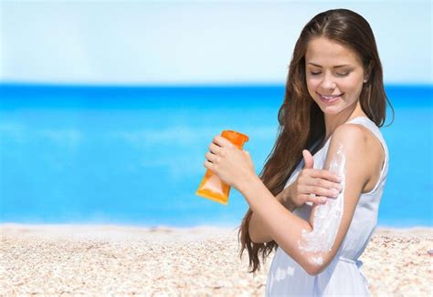 Foto de una persona aplicando crema solar en la playa