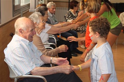 Foto de niños y ancianos interactuando y sonriendo en un centro comunitario