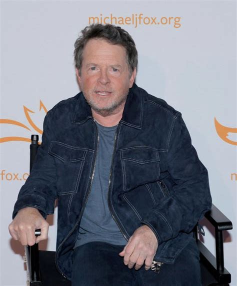 Michael J. Fox en una alfombra roja, sonriendo.