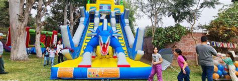 Foto de niños y familias en una actividad comunitaria con juegos inflables y artistas circenses