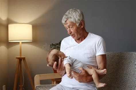 Foto de un abuelo sosteniendo a un recién nacido