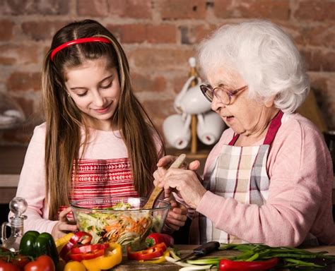 Foto de abuela y nieta cocinando juntas en la cocina.