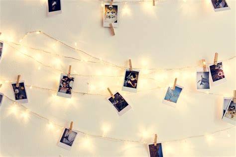Tablero de madera rústica con varias fotos colgadas con pinzas pequeñas